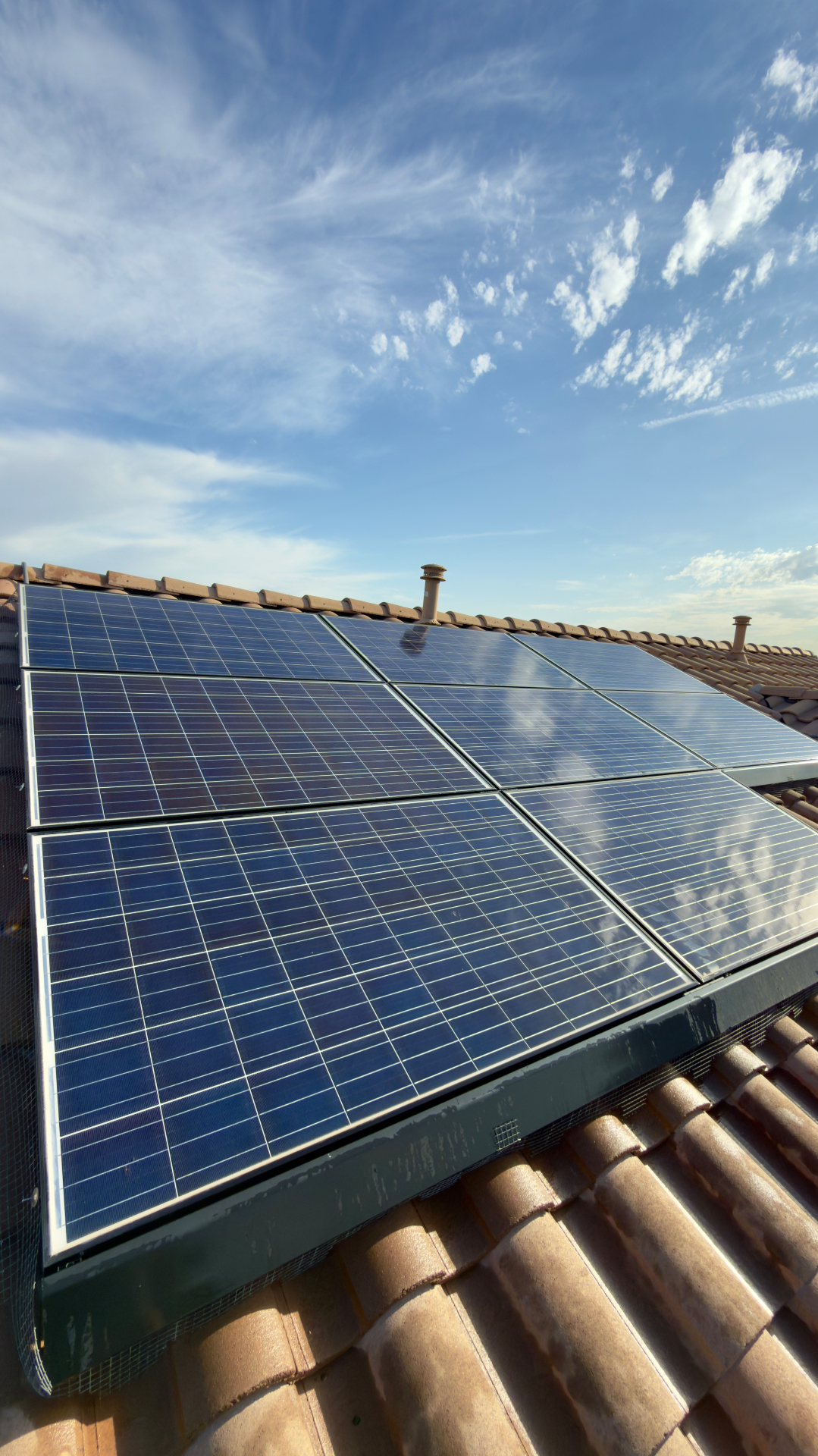 Glossy cleaned solar panels on a terracotta-tile roof