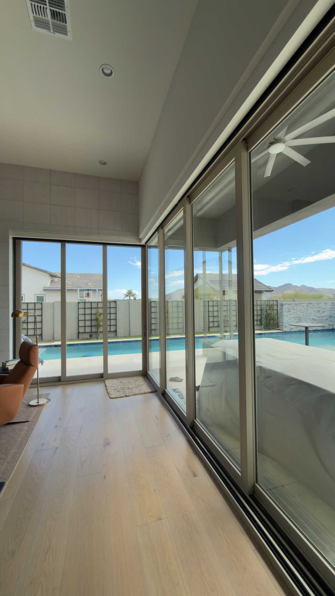 Clean sliding glass doors looking out to a pool and patio